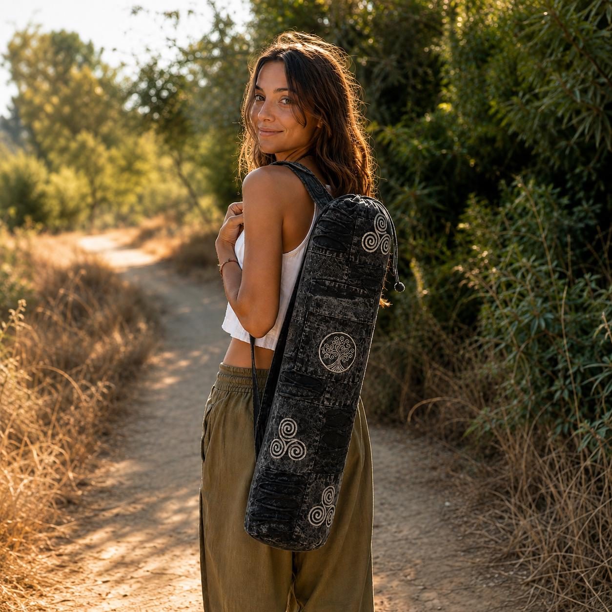 Woman carrying a manaKAmana yoga mat bag on a trail